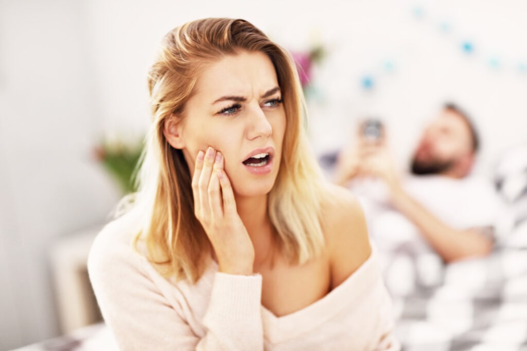woman holding face with a toothache
